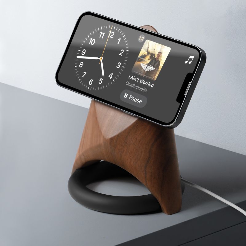 Futuristic wooden charging station with MagSafe for smartphones, featuring a modern design and sleek clock display.