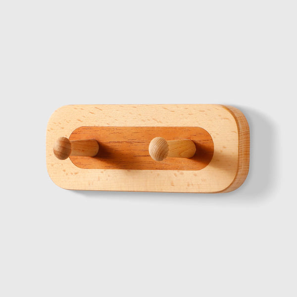Crochet double wall hook in solid red oak and walnut by Frêne, featuring two rounded wooden pegs.