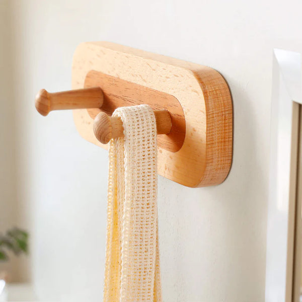 Wooden wall-mounted crochet hook rack in red oak with two sturdy pegs for hanging