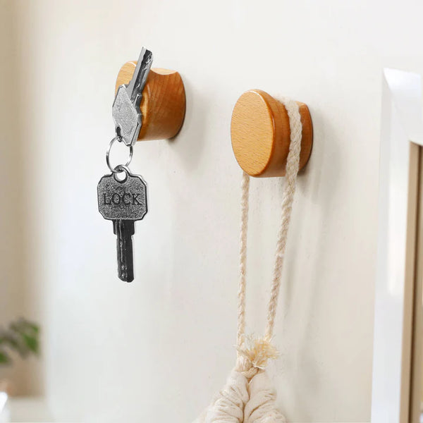 Wall-mounted magnetic hooks in wood finish, ideal for holding keys and bathroom accessories. By Chêne Rouge.