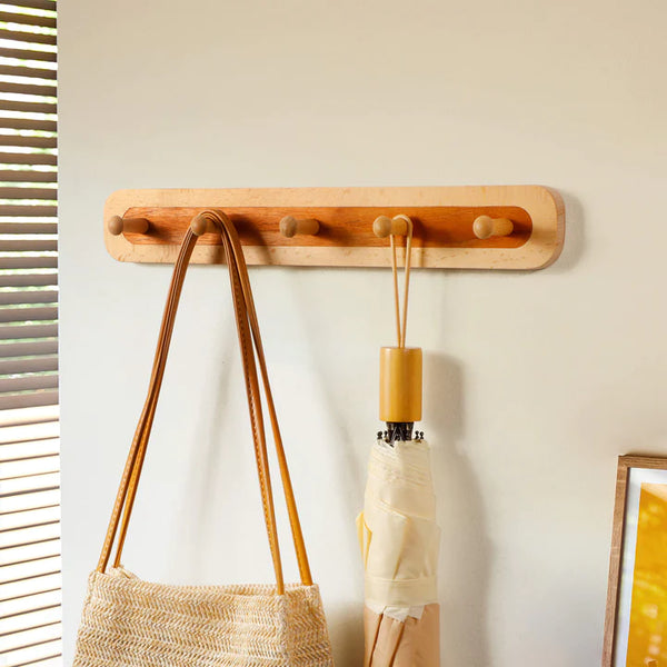 Wooden wall coat rack with five hooks, featuring a natural finish, ideal for entryway organization. By Frêne.