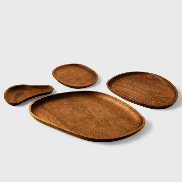 Artisanal wooden plates set by Noyer noir, featuring unique engravings and natural brown finish.
