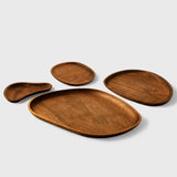 Artisanal wooden plates set by Noyer noir, featuring unique engravings and natural brown finish.