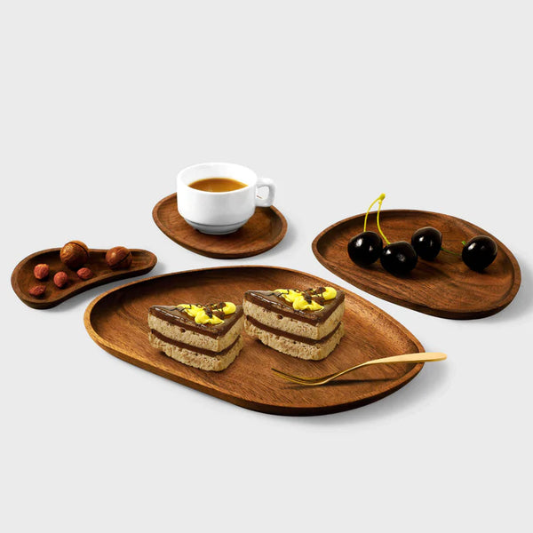 Assorted handcrafted wooden plates and bowls by Noyer noir, featuring a dark walnut finish and elegant curves.