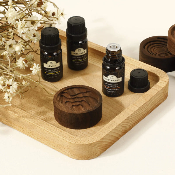 Diffuseur d'huiles essentielles en noyer noir avec flacons d'huiles essentielles et plateau en bois naturel.