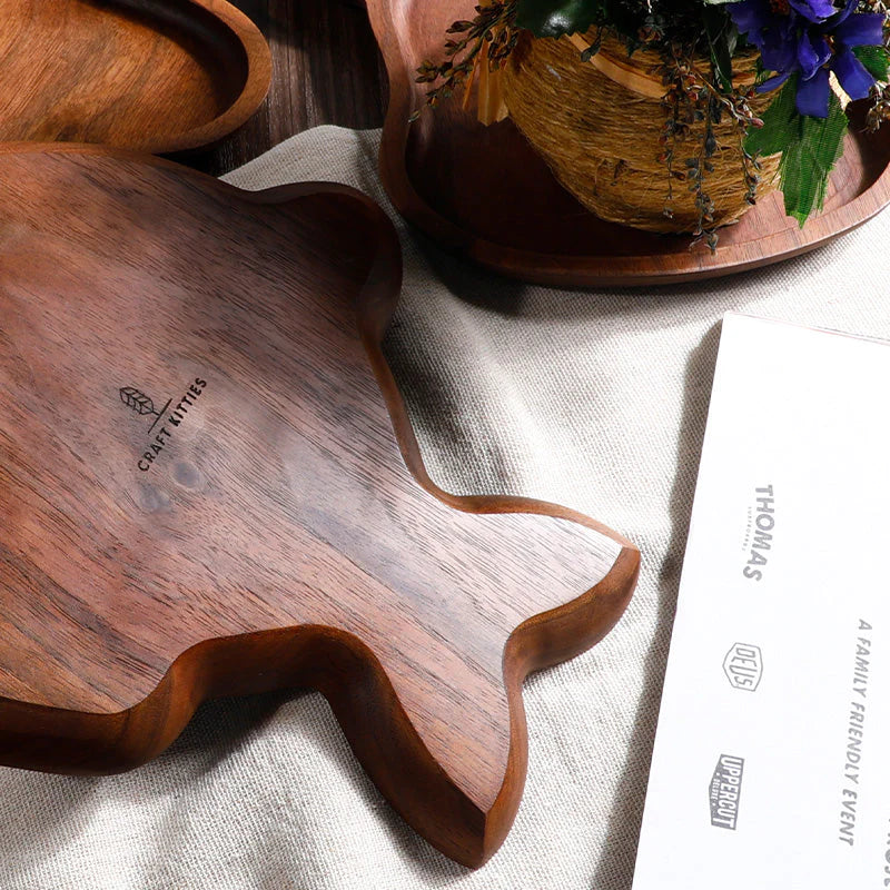Artisanal walnut fish-shaped decorative plate by Noyer Noir with personalized engraving, showcasing natural wood grain.