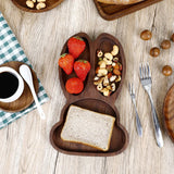 Artisanal wooden bunny-shaped plate with strawberries, nuts, and bread, by Noyer noir.